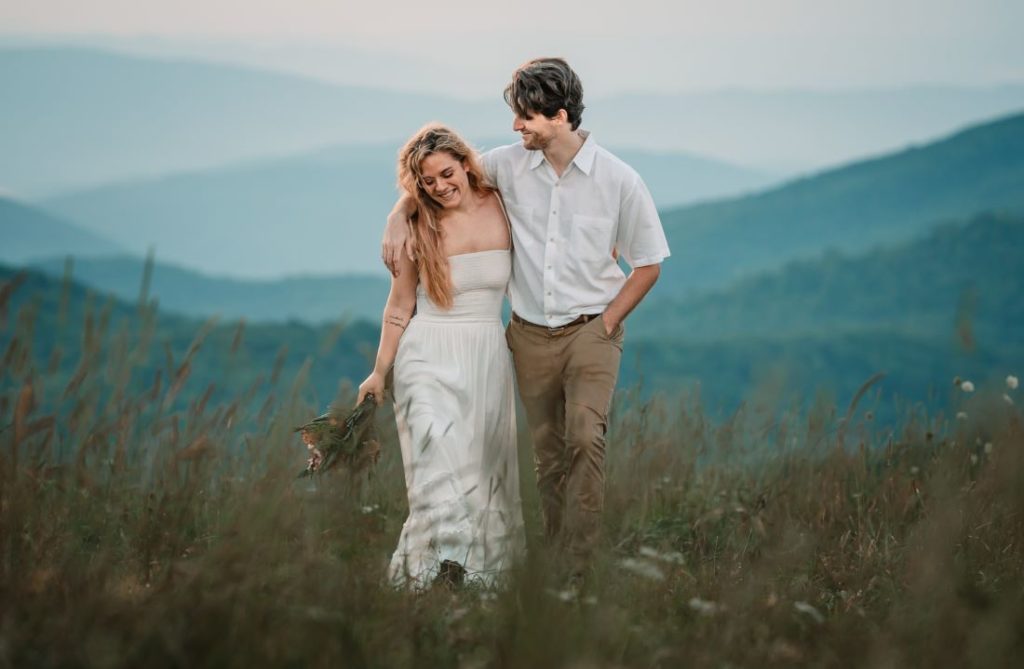 a happy couple walking side by side with his arms around her shoulders for their max patch elopement