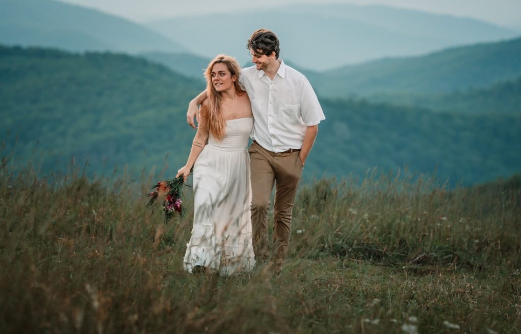 the sun glints off the bride's hair as she walks with her husband during a max patch elopement